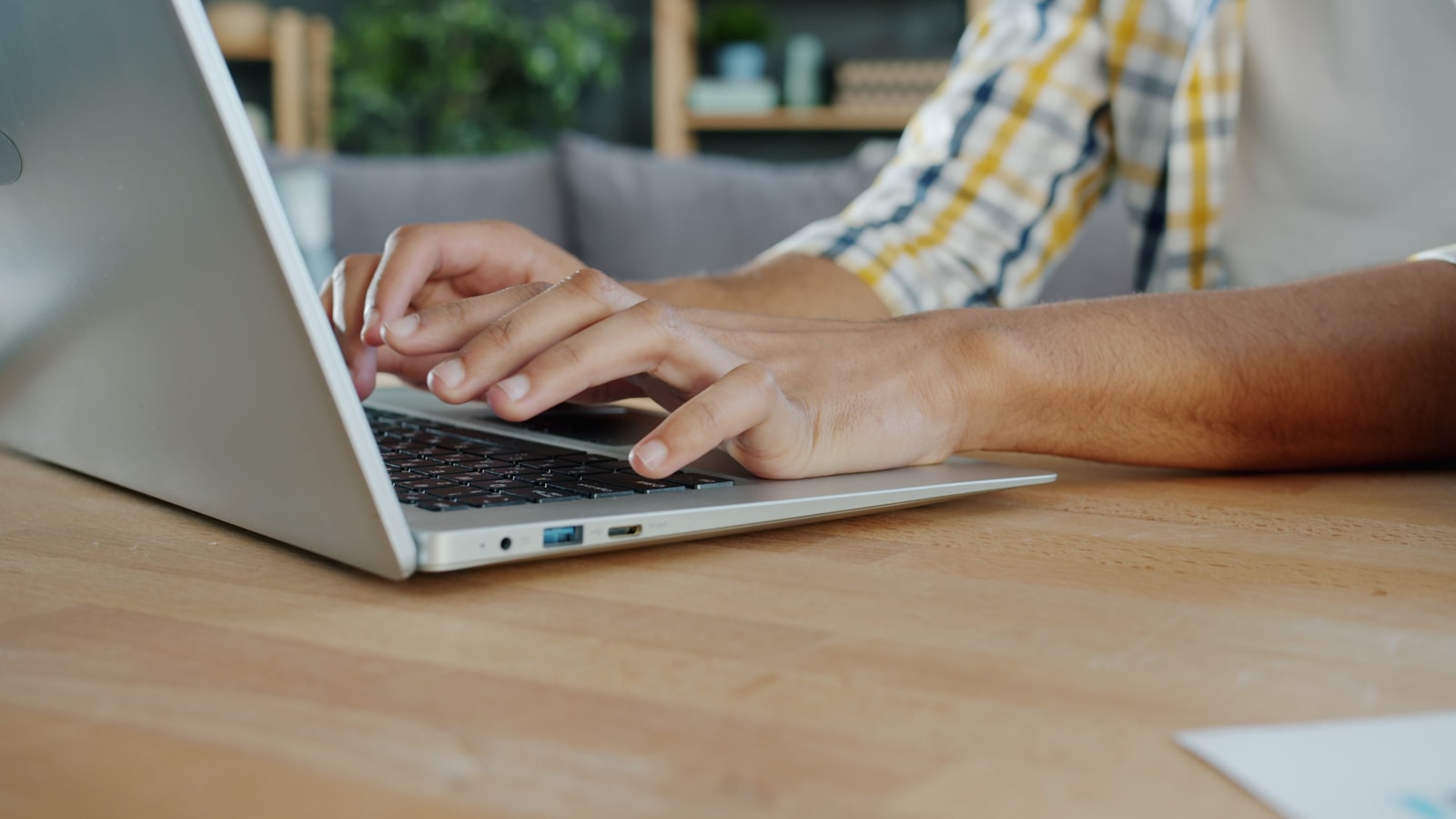 Gros plan de mains tapant sur le clavier d'un ordinateur portable.