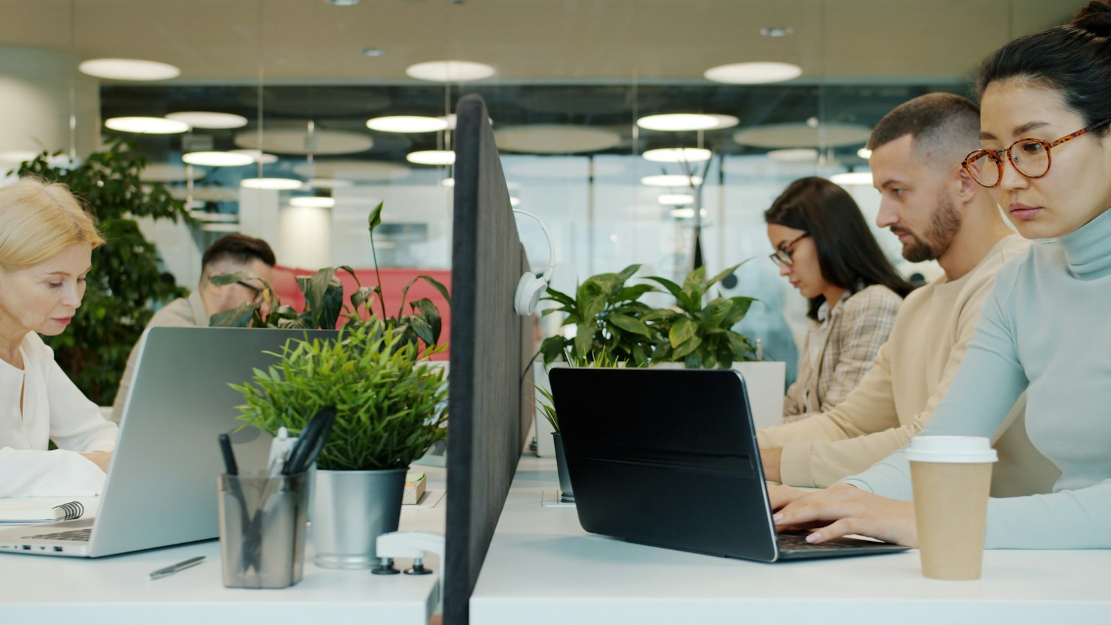 Image d'illustration — des salariés travaillent sur ordinateurs portables dans un espace de travail partagé.