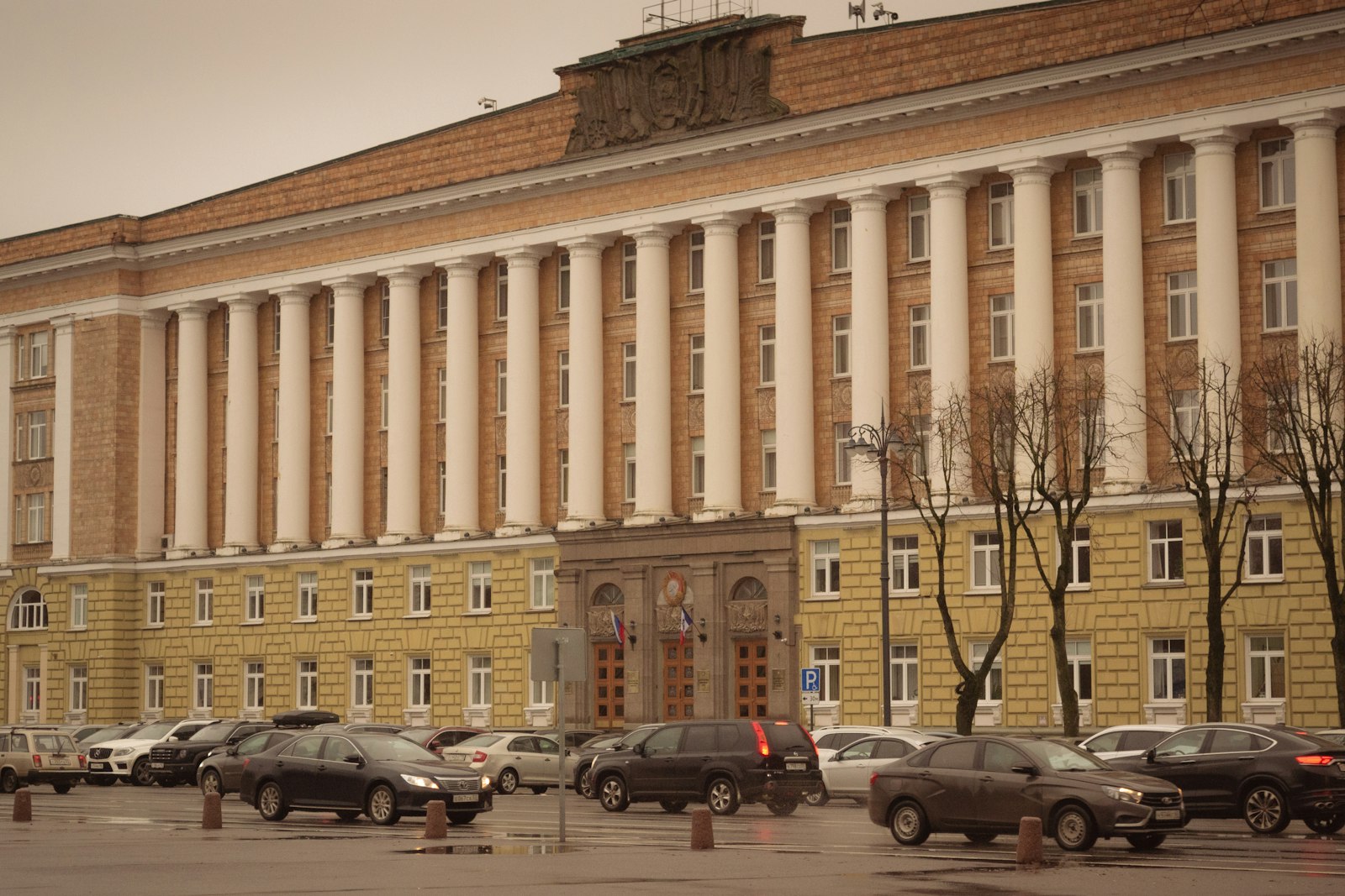 Image d'illustration — Large building with many columns and cars parked outside