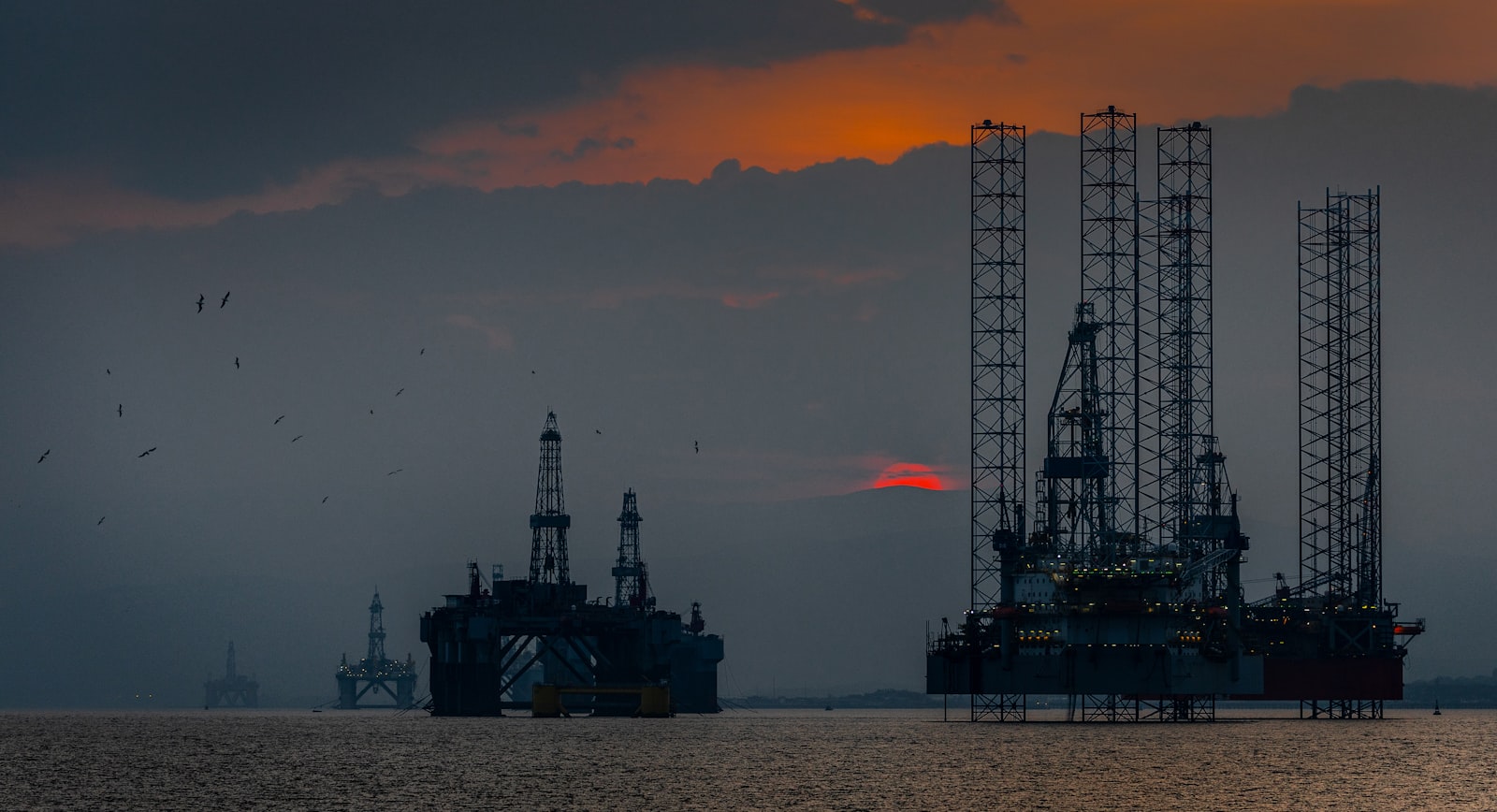 Image d'illustration — plateforme d'exploration en mer au coucher du soleil.