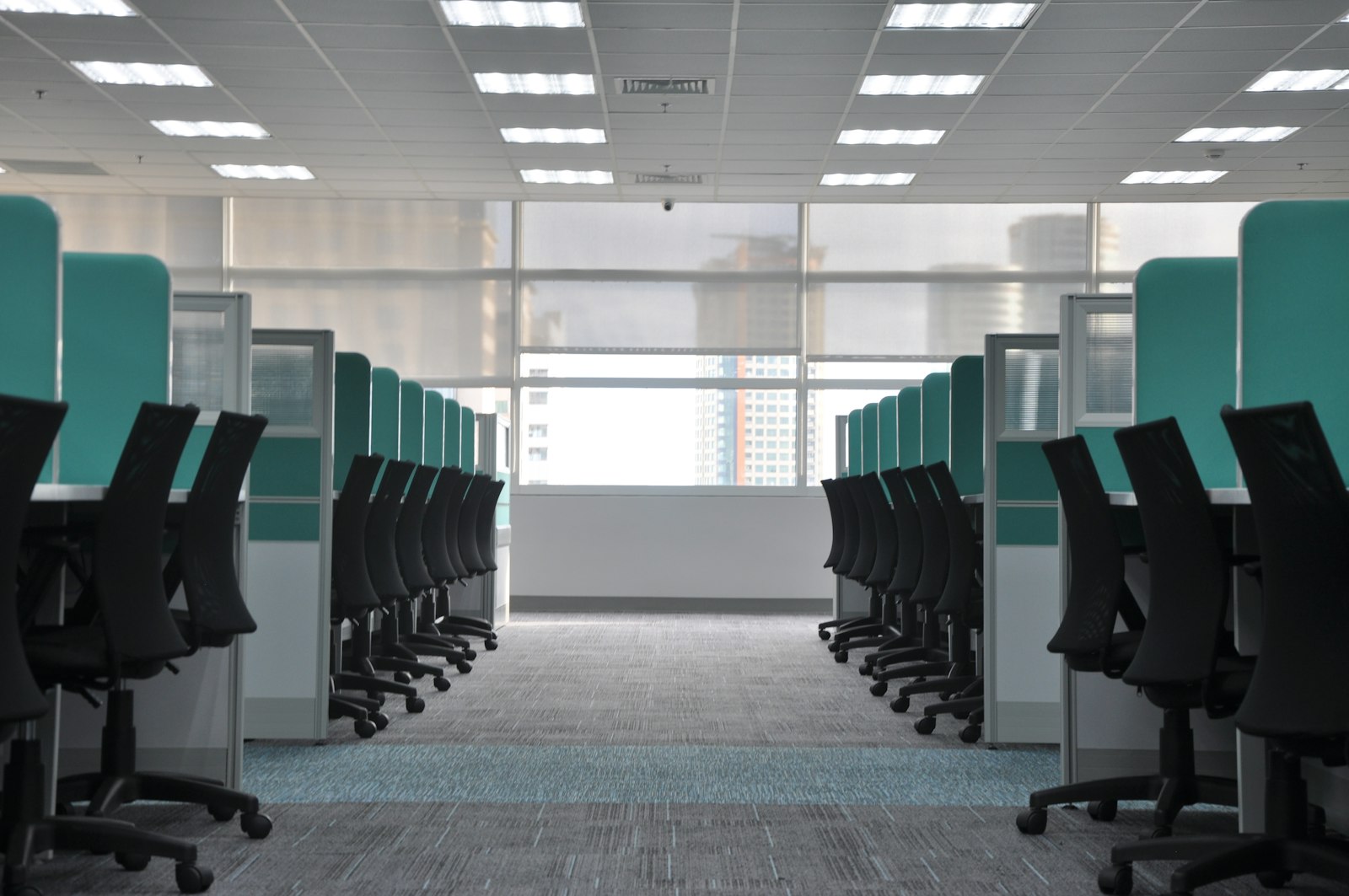 Image d'illustration — bureaux vides, chaises à roulettes dans des cubicules désertés
