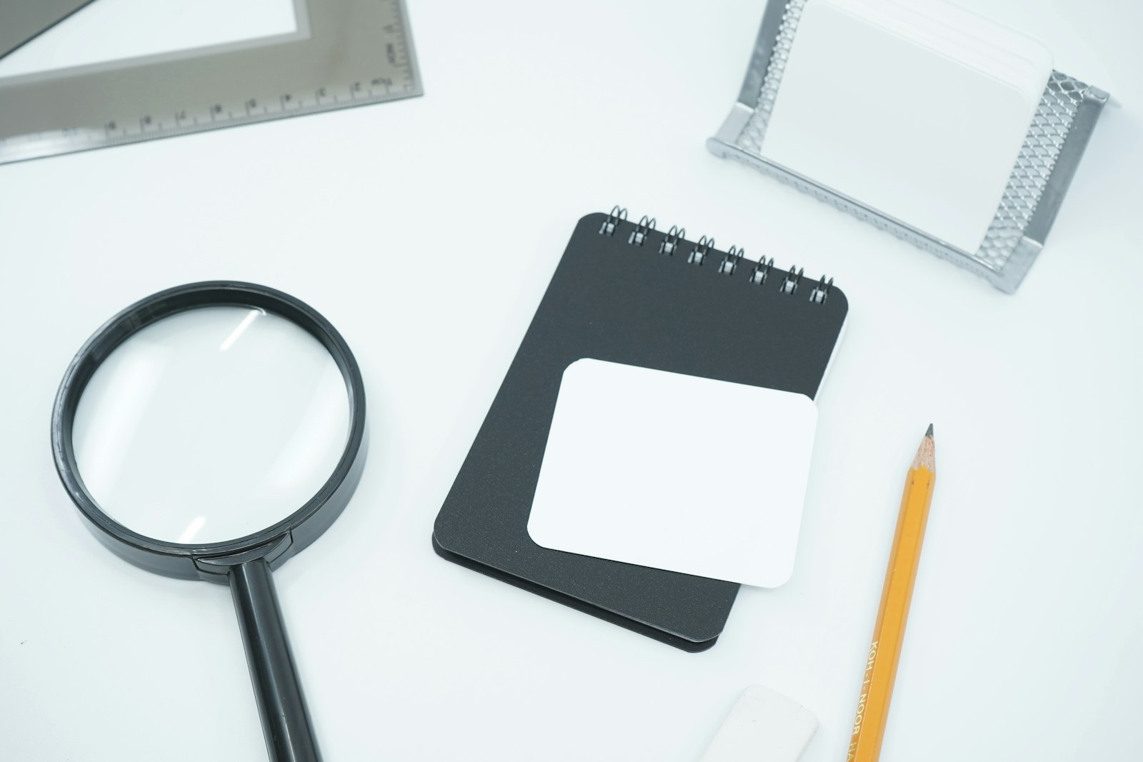 Une loupe noire posée sur une feuille de papier blanc, évoquant la vérification et l'examen minutieux d'un document.